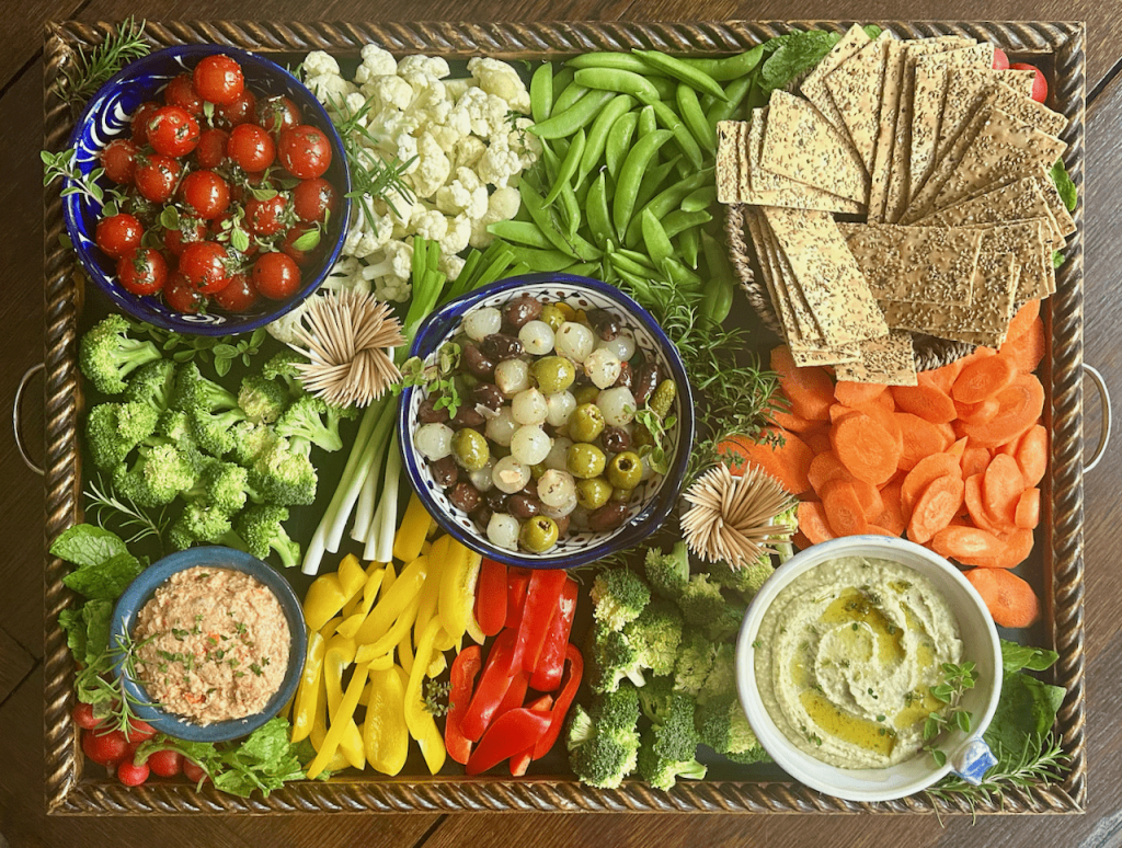 A wooden board with seasonal vegetables, grains and herbs arranged for the week